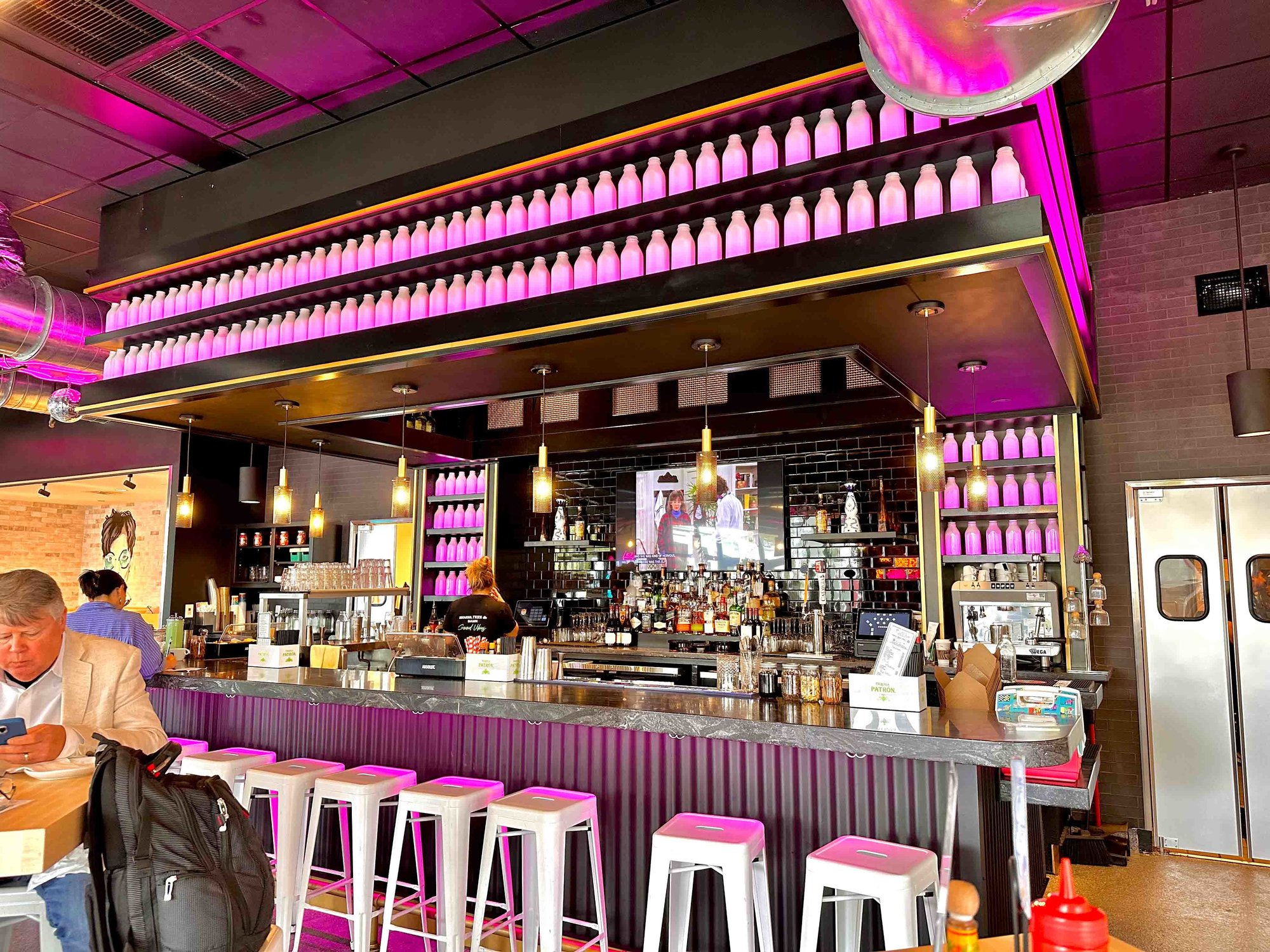Pink neon bar inside restaurant with television